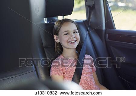 Stock Image - Girl wearing seat belt. Fotosearch