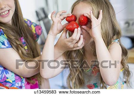 Girl with strawberries covering her eyes View Large Photo Image Stock Image - Girl with strawberries covering her eyes. Fotosearch