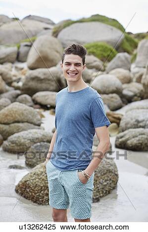 Stock Photography - Man on beach smiling towards camera. Fotosearch
