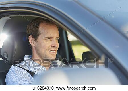 Stock Image - Mid adult man in car. Fotosearch