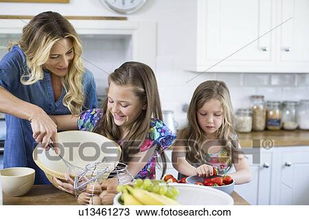 Stock Image - Mother and children in the kitchen. Fotosearch