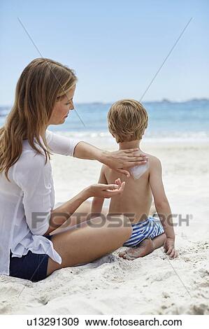 Mother applying sun cream to son View Large Photo Image Stock Photo - Mother applying sun cream to son. Fotosearch