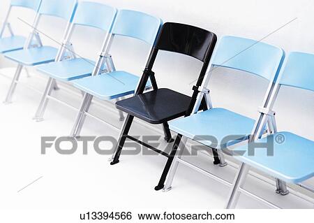 One black chair in a row of blue chairs View Large Photo Image Stock Photograph - One black chair in a row of blue chairs. Fotosearch