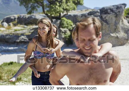 Stock Photo - Parents giving children piggy backs. Fotosearch