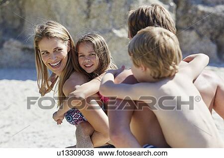 Stock Photo - Parents giving children piggy backs. Fotosearch