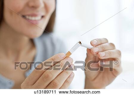 Person breaking cigarette in half View Large Photo Image Stock Image - Person breaking cigarette in half. Fotosearch