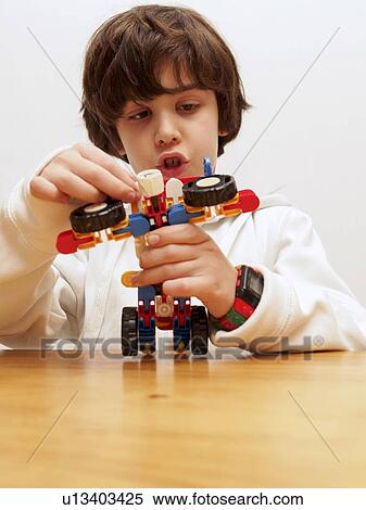 playing with a toy robot View Large Photo Image Stock Photography - playing with a toy robot. Fotosearch