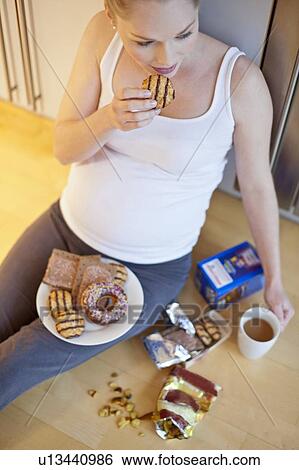 Pregnant woman eating biscuit View Large Photo Image Stock Photograph - Pregnant woman eating biscuit. Fotosearch