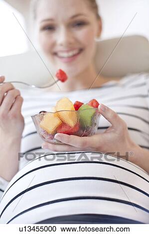 Pregnant woman eating fruit salad View Large Photo Image Stock Image - Pregnant woman eating fruit salad. Fotosearch
