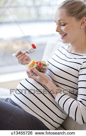 Pregnant woman eating fruit salad View Large Photo Image Stock Photograph - Pregnant woman eating fruit salad. Fotosearch