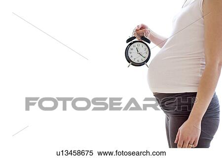 Pregnant woman holding alarm clock View Large Photo Image Stock Photography - Pregnant woman holding alarm clock. Fotosearch