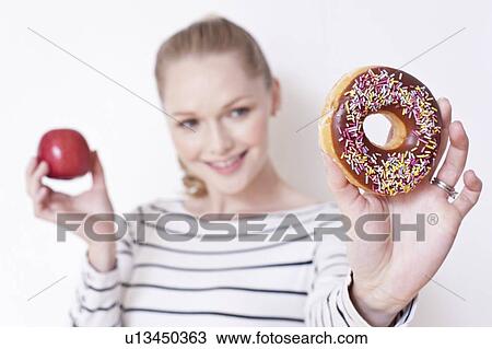 Pregnant woman holding apple and doughnut View Large Photo Image Stock Image - Pregnant woman holding apple and doughnut. Fotosearch