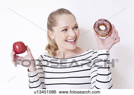 Pregnant woman holding apple and doughnut View Large Photo Image Stock Photograph - Pregnant woman holding apple and doughnut. Fotosearch