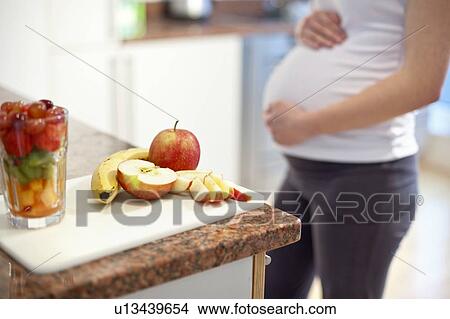 Pregnant woman in kitchen View Large Photo Image Picture - Pregnant woman in kitchen. Fotosearch