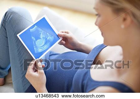 Pregnant woman looking at baby scan View Large Photo Image Stock Image - Pregnant woman looking at baby scan. Fotosearch