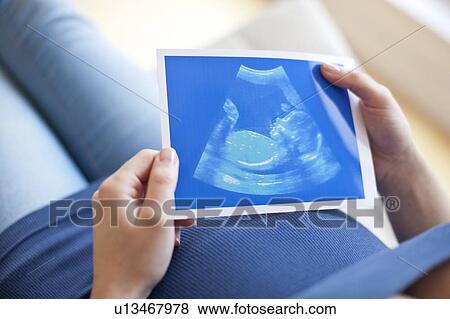 Pregnant woman looking at baby scan View Large Photo Image Stock Photo - Pregnant woman looking at baby scan. Fotosearch