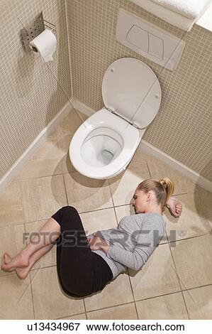 Stock Photo - Pregnant woman lying on bathroom floor. Fotosearch