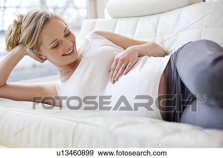 Pregnant woman lying on sofa View Large Photo Image Stock Photo - Pregnant woman lying on sofa. Fotosearch