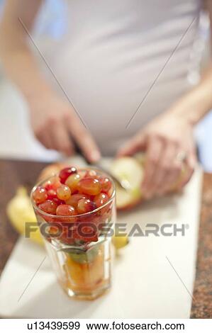 Pregnant woman preparing fresh fruit View Large Photo Image Stock Photo - Pregnant woman preparing fresh fruit. Fotosearch