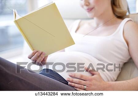Picture - Pregnant woman reading book. Fotosearch