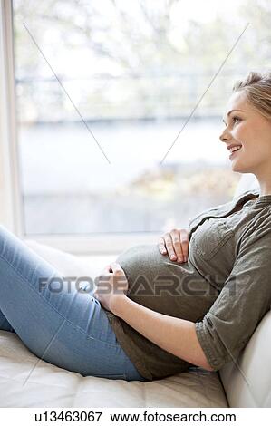 Pregnant woman touching tummy View Large Photo Image Stock Photo - Pregnant woman touching tummy. Fotosearch
