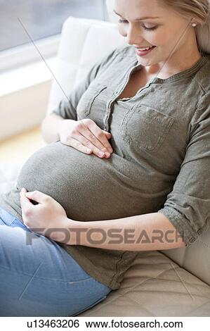 Pregnant woman touching tummy View Large Photo Image Stock Photograph - Pregnant woman touching tummy. Fotosearch