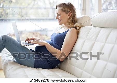 Stock Photograph - Pregnant woman using laptop. Fotosearch