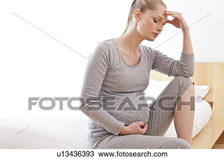 Stock Image - Pregnant woman with hand on head. Fotosearch