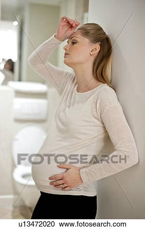 Stock Image - Pregnant woman with hand on head. Fotosearch