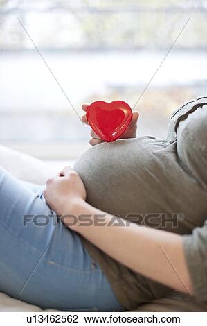 Pregnant woman with heart shape on tummy View Large Photo Image Stock Image - Pregnant woman with heart shape on tummy. Fotosearch