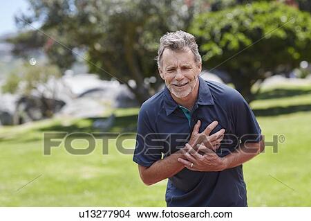 Senior man holding his chest in pain View Large Photo Image Picture - Senior man holding his chest in pain. Fotosearch