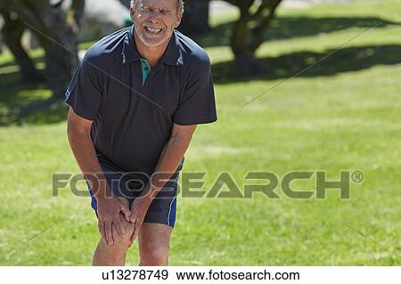 Senior man holding his knee in pain View Large Photo Image Stock Photo - Senior man holding his knee in pain. Fotosearch