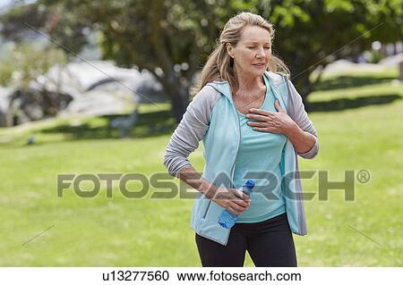 Senior woman holding chest in pain View Large Photo Image Stock Image - Senior woman holding chest in pain. Fotosearch