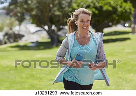 Stock Image - Senior woman listening to music. Fotosearch