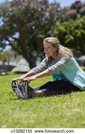 Senior woman stretching on grass View Large Photo Image Stock Photography - Senior woman stretching on grass. Fotosearch