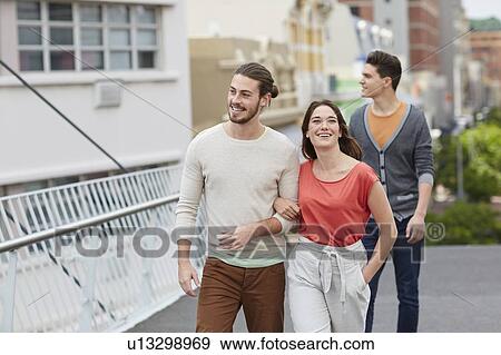Three young friends walking View Large Photo Image Stock Photo - Three young friends walking. Fotosearch