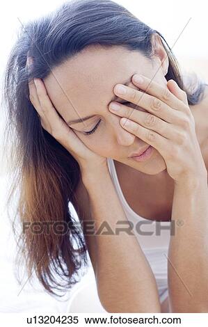 Stock Photography - Tired young woman rubbing her eyes. Fotosearch