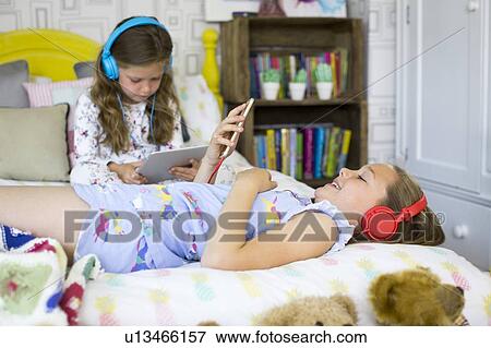 Stock Photo - Two sisters in bedroom. Fotosearch