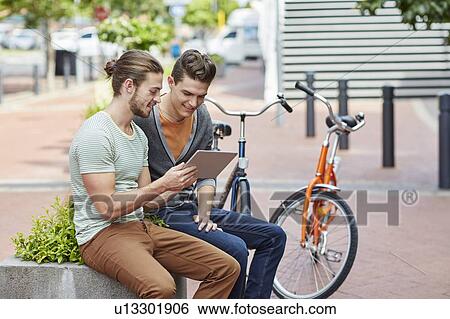 Two young men with digital tablet View Large Photo Image Stock Photograph - Two young men with digital tablet. Fotosearch