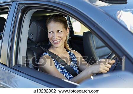 Stock Image - Woman looking through car window. Fotosearch