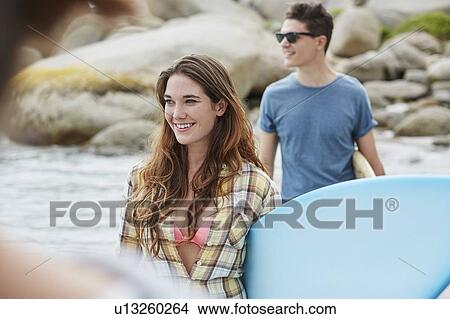 Picture - Woman on beach with surfboard. Fotosearch