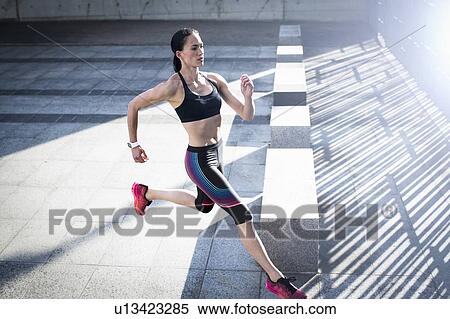 Woman running across concrete, high angle View Large Photo Image Stock Photography - Woman running across concrete, high angle. Fotosearch
