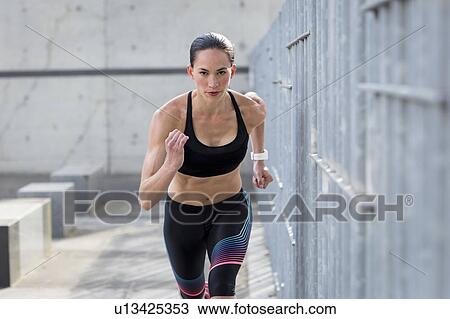 Stock Image - Woman running towards camera. Fotosearch