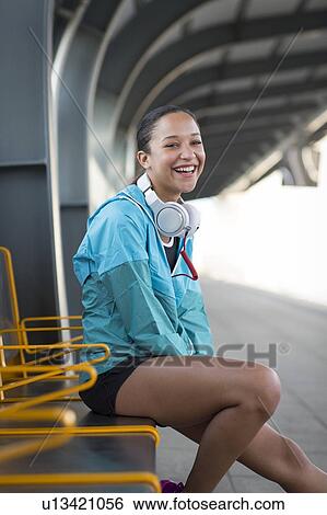Woman sitting on railway platform smiling View Large Photo Image Stock Photograph - Woman sitting on railway platform smiling. Fotosearch
