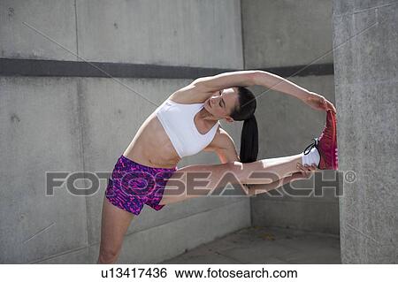Woman stretching against wall View Large Photo Image Stock Photograph - Woman stretching against wall. Fotosearch