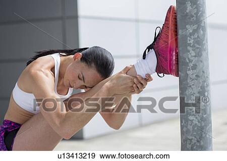 Stock Photo - Woman stretching leg muscles. Fotosearch