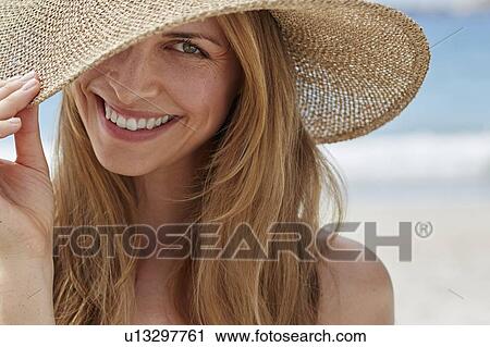 Stock Image - Woman wearing a sunhat. Fotosearch
