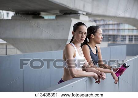 Stock Image - Women in sports clothing resting. Fotosearch