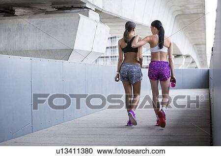 Stock Image - Women in sports wear walking away. Fotosearch