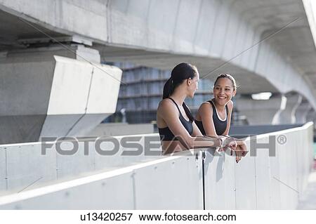 Stock Photo - Women leaning on wall in sports wear. Fotosearch